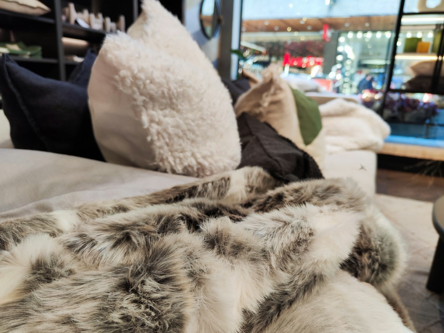 Nahaufnahme einer weichen Decke und Kissen auf einem Sofa