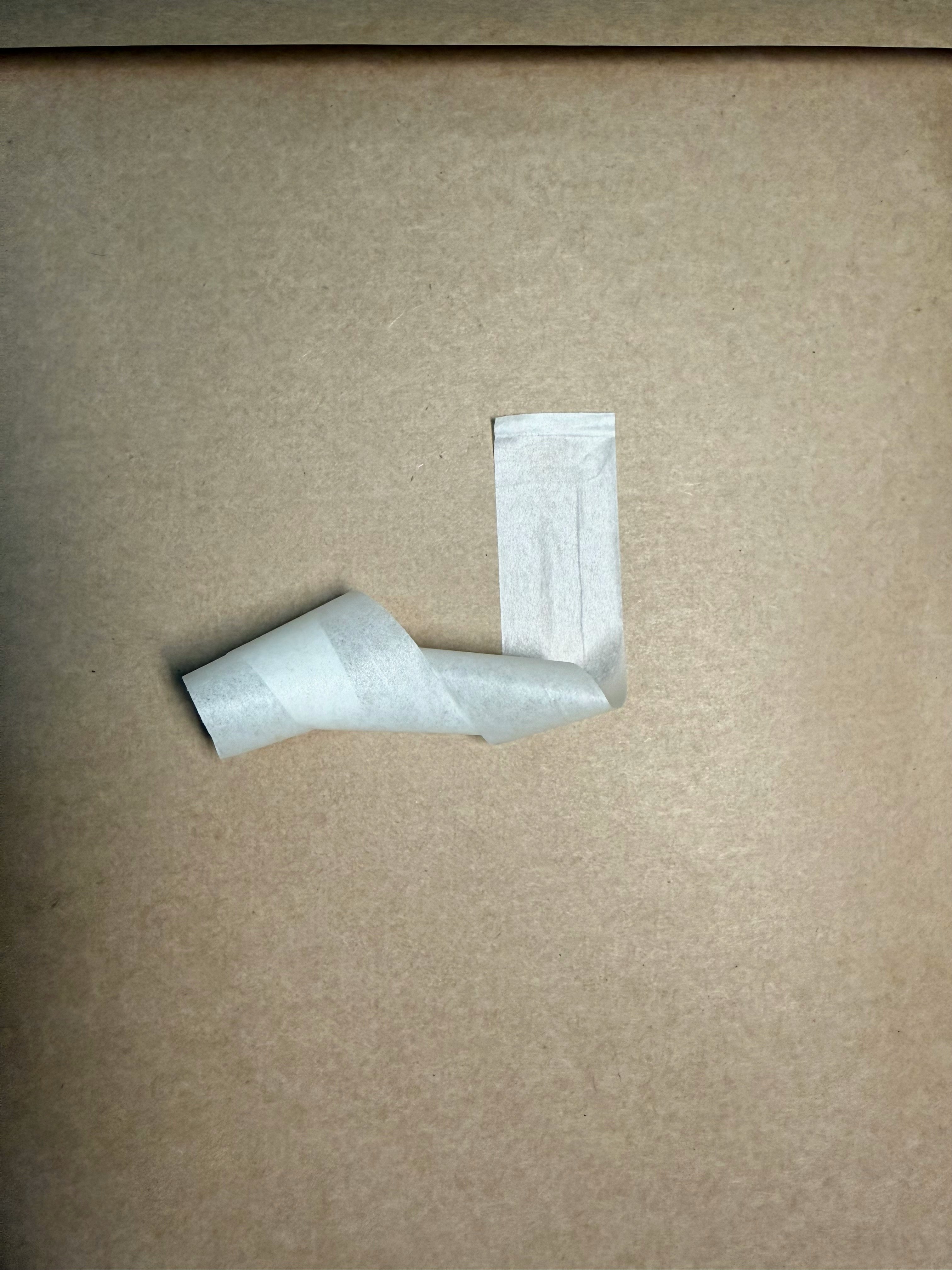 restes de ruban blanc sur un mur beige