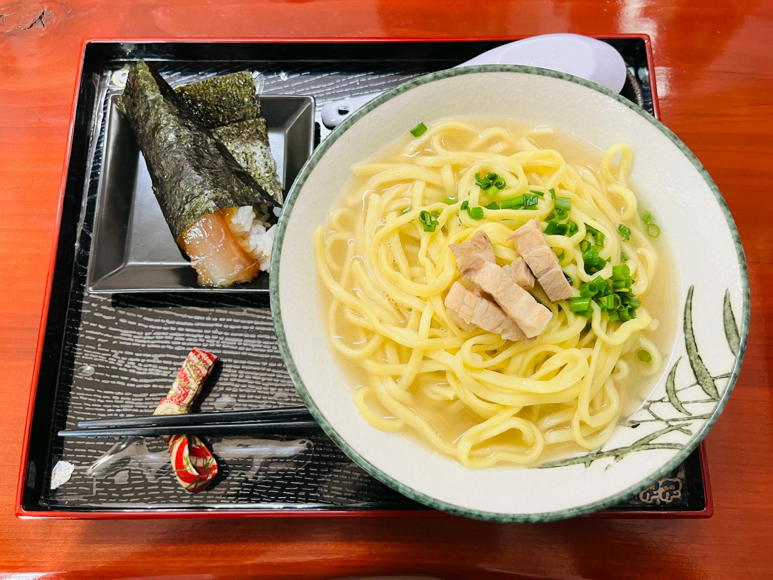 Mì ramen nóng được phục vụ trong bát trắng với thịt gà thái lát và hành lá