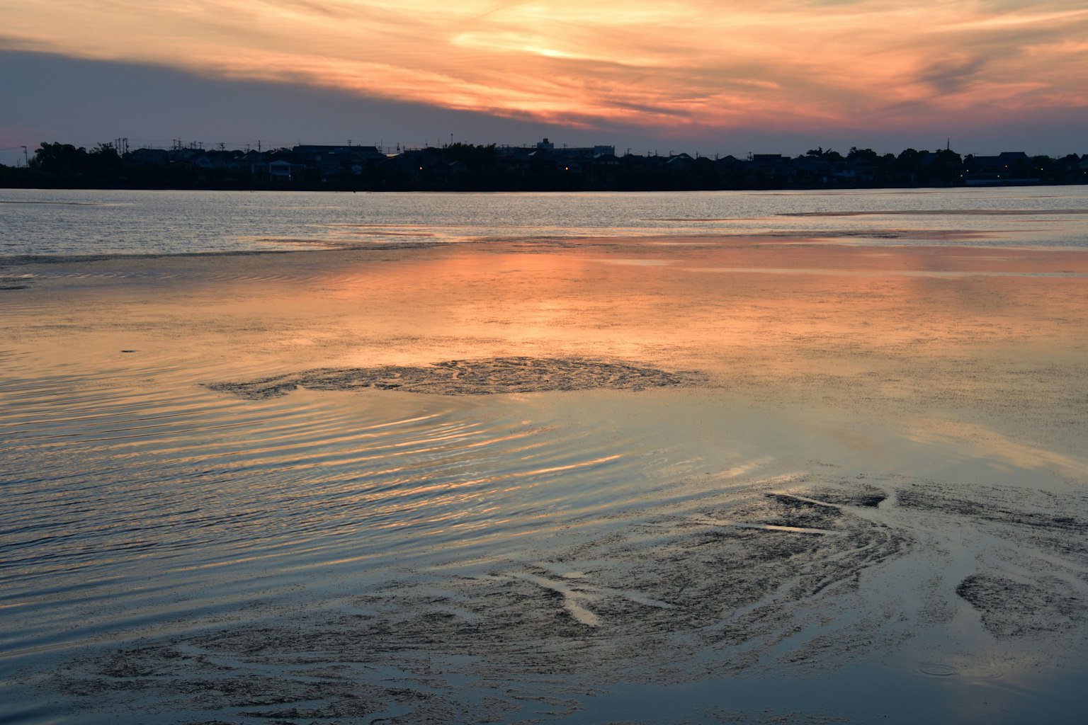 Ruhiges Wasser, das die Farben des Sonnenuntergangs widerspiegelt