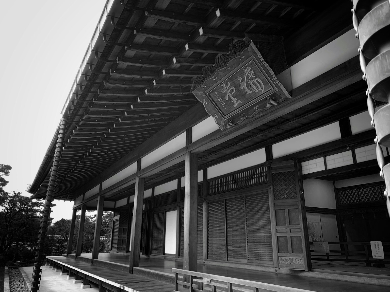 Schwarzweißfoto eines schönen Holzgebäudes mit traditionellem japanischen Design und Veranda