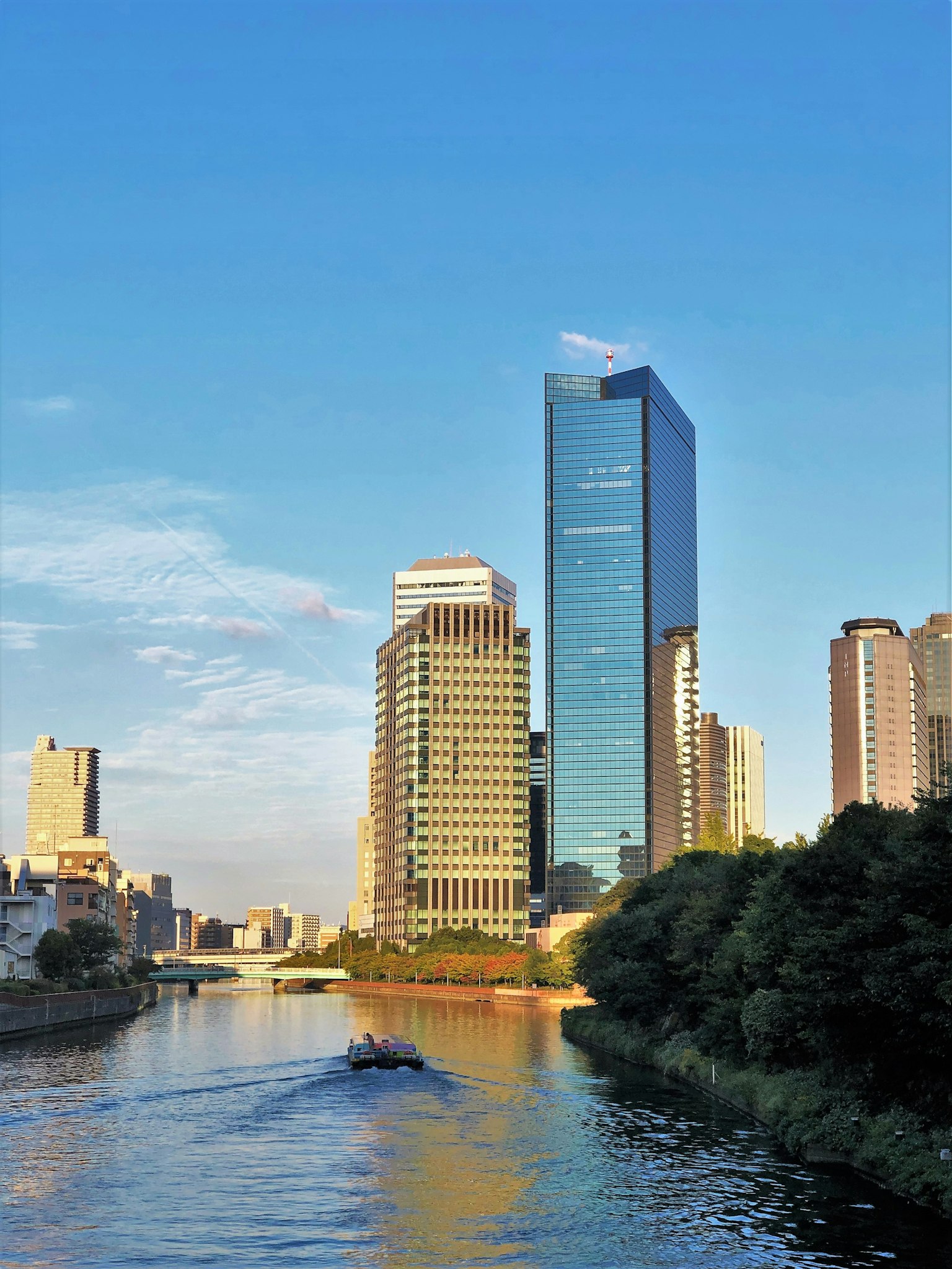藍天之下河邊現代摩天大樓的城市天際線