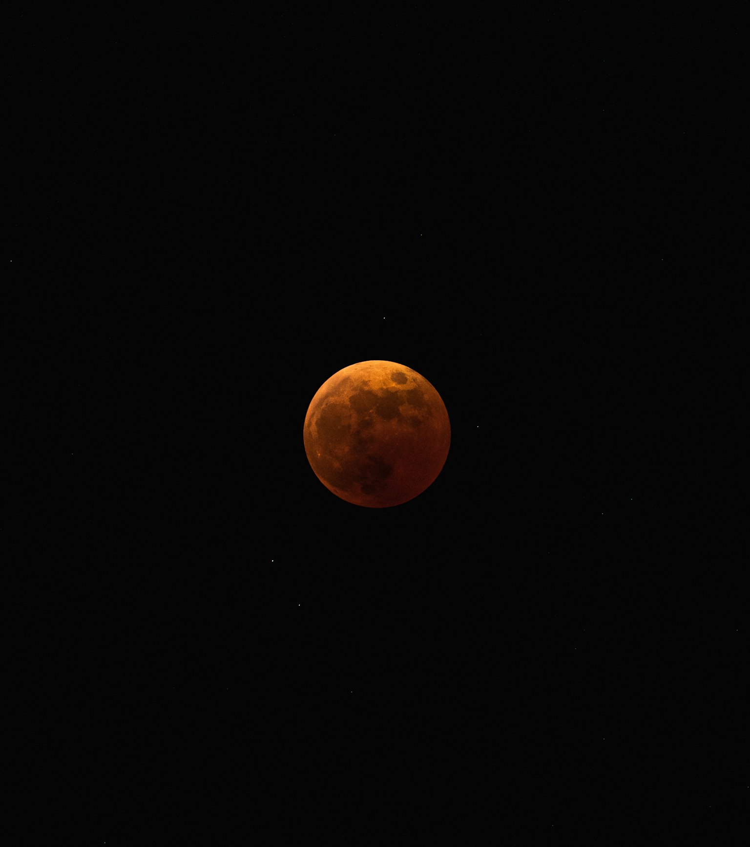 Lune rouge flottant dans un ciel nocturne sombre