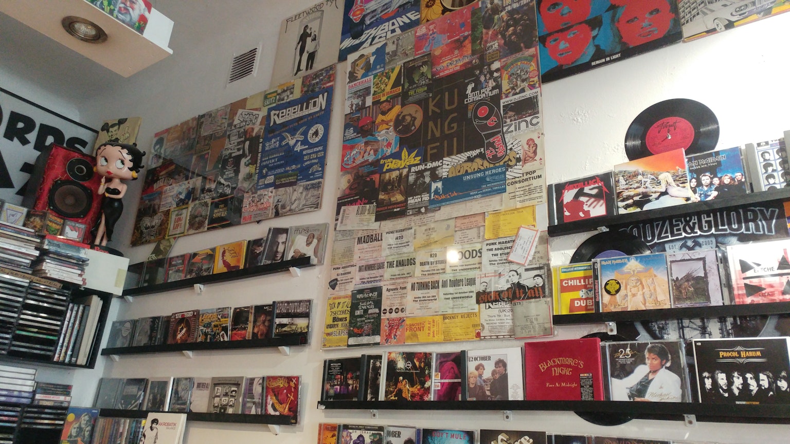 Chambre avec des murs couverts de posters et de CD de musique