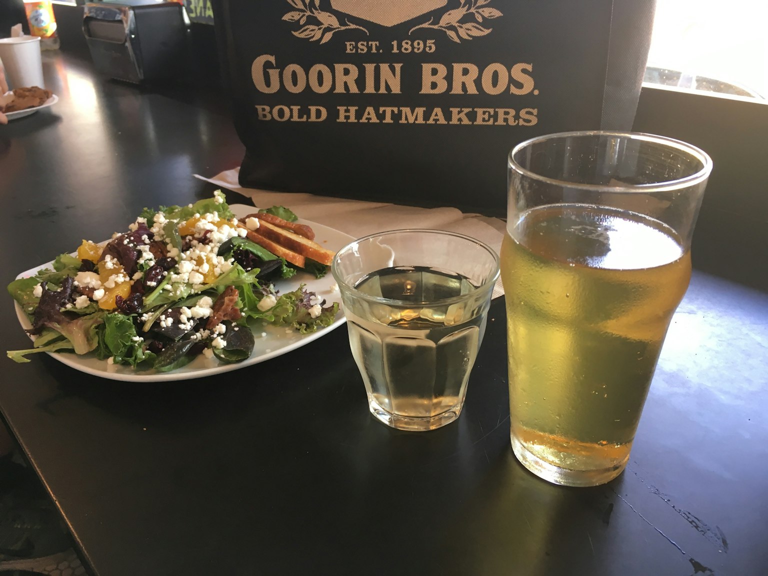 Tisch mit Salat und Getränken einschließlich einem Glas Bier und einem Shot-Glas