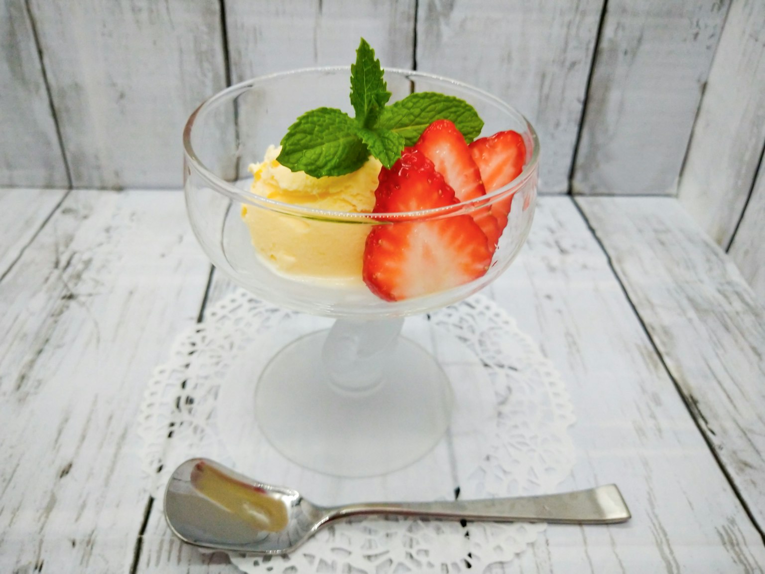 Dessert krim dengan hiasan stroberi dan mint