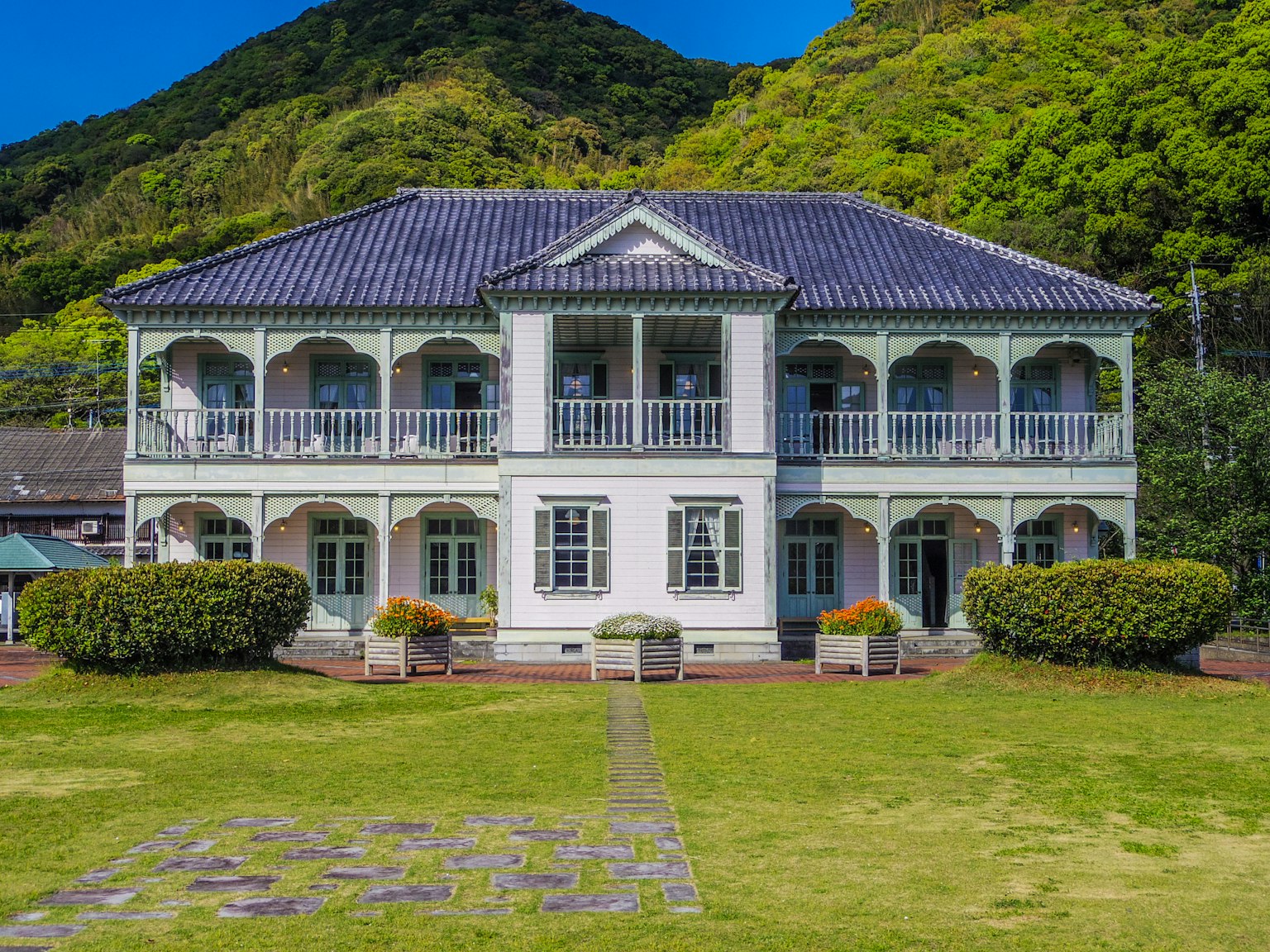 Maison historique de style occidental entourée de verdure luxuriante