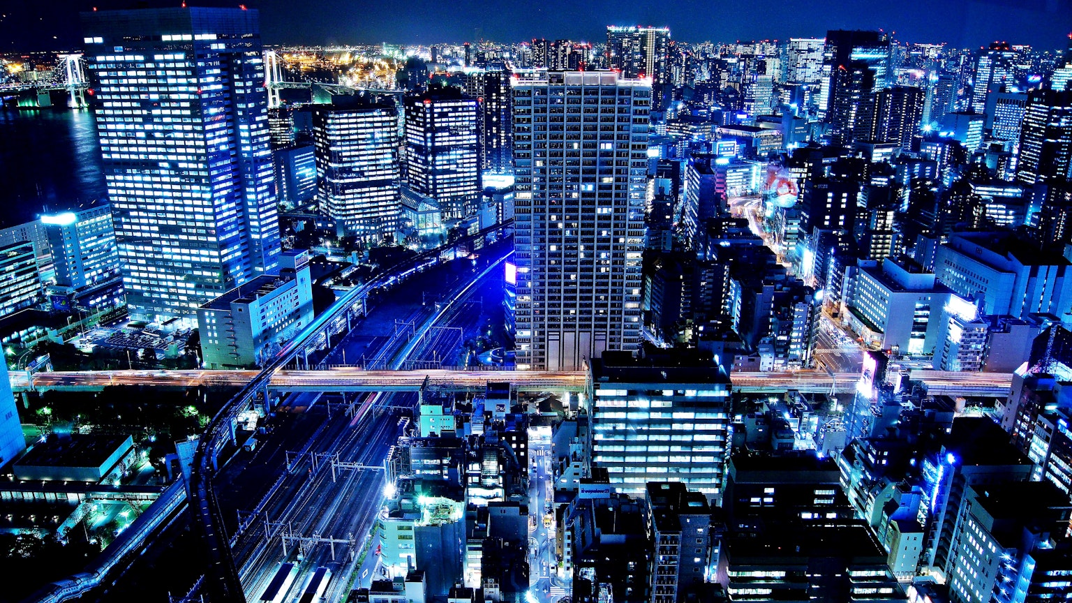 ทิวทัศน์เมืองในตอนกลางคืน ตึกสูงและแสงสีน้ำเงินที่โดดเด่น