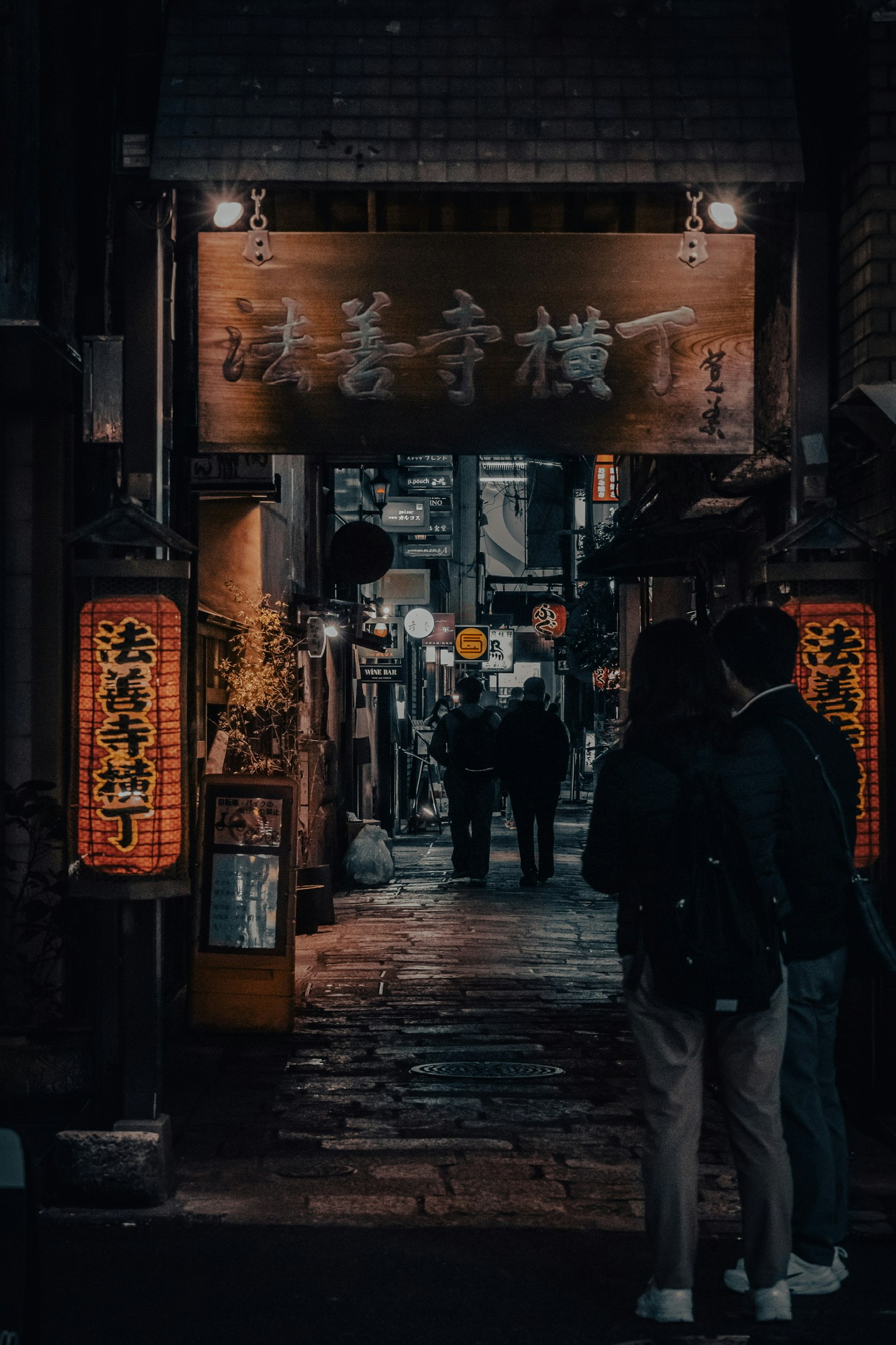 Entrance of an izakaya in a dark alley with lanterns