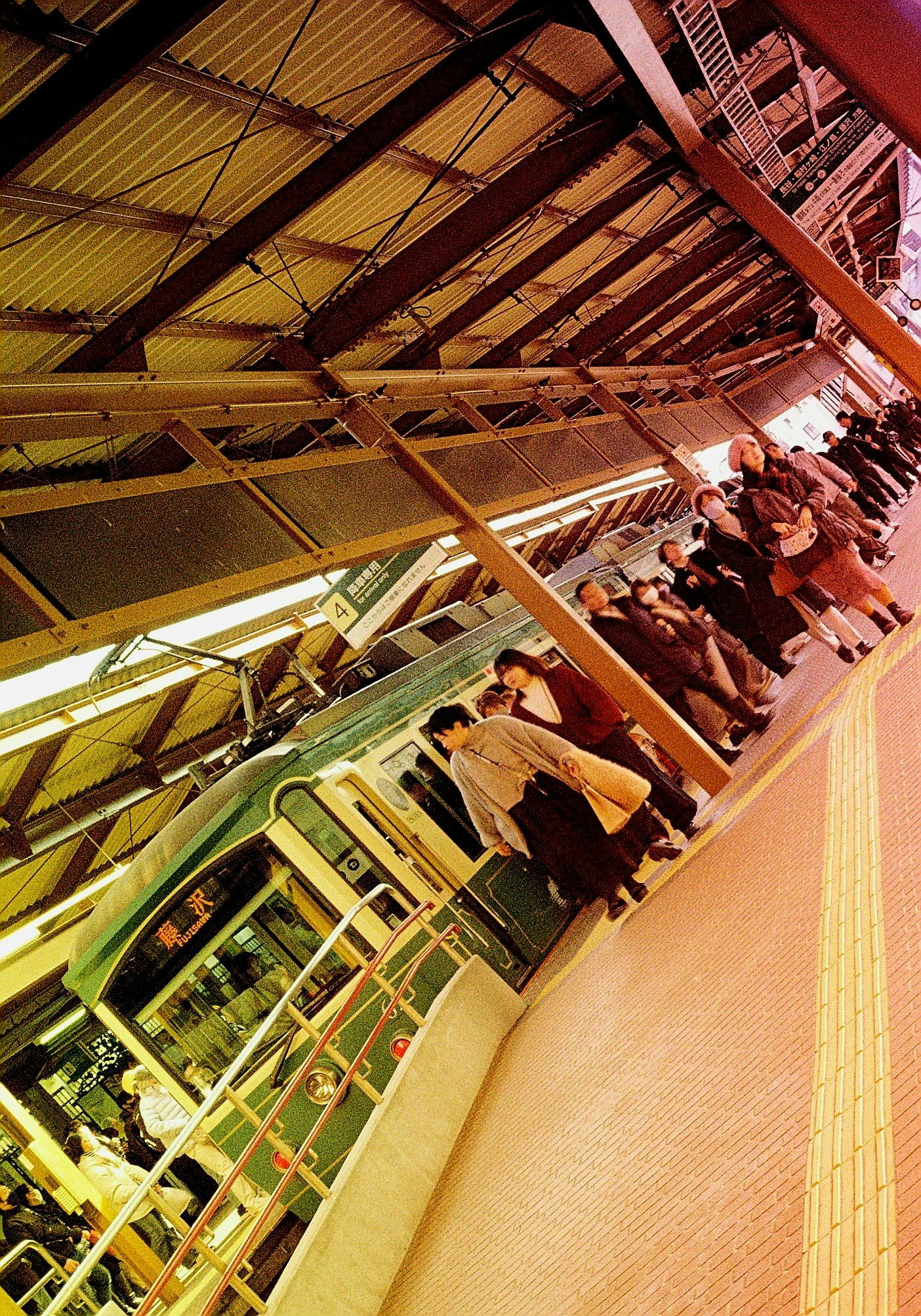 雨の鎌倉の駅ホームで並ぶ電車と人々