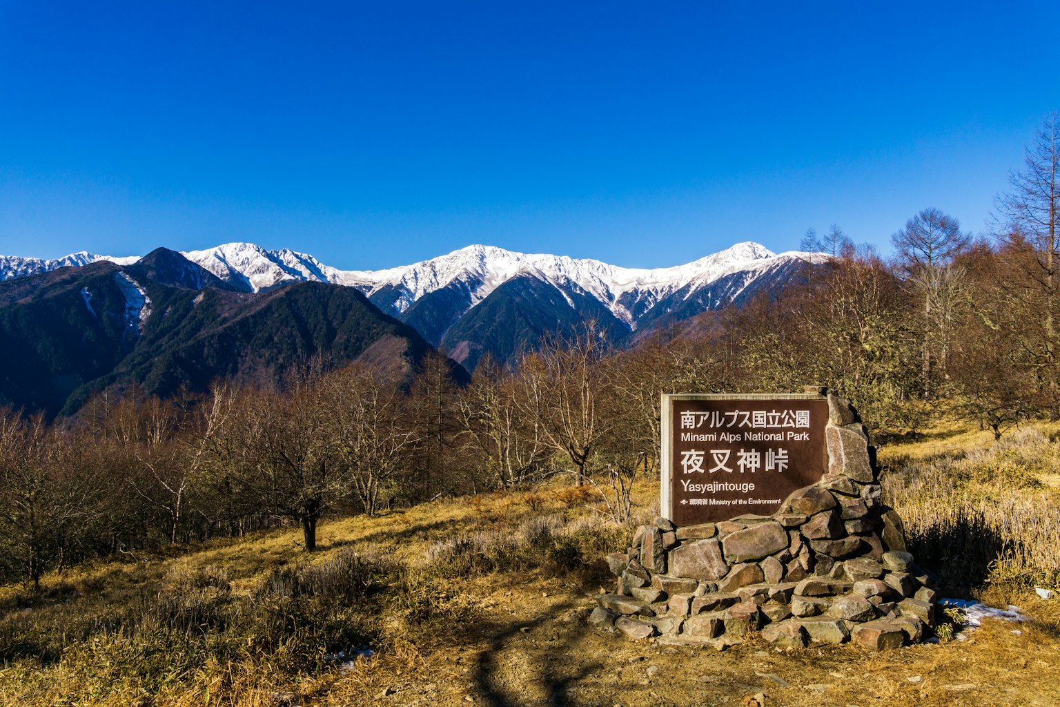 Cartel en un paisaje con montañas nevadas y cielo azul