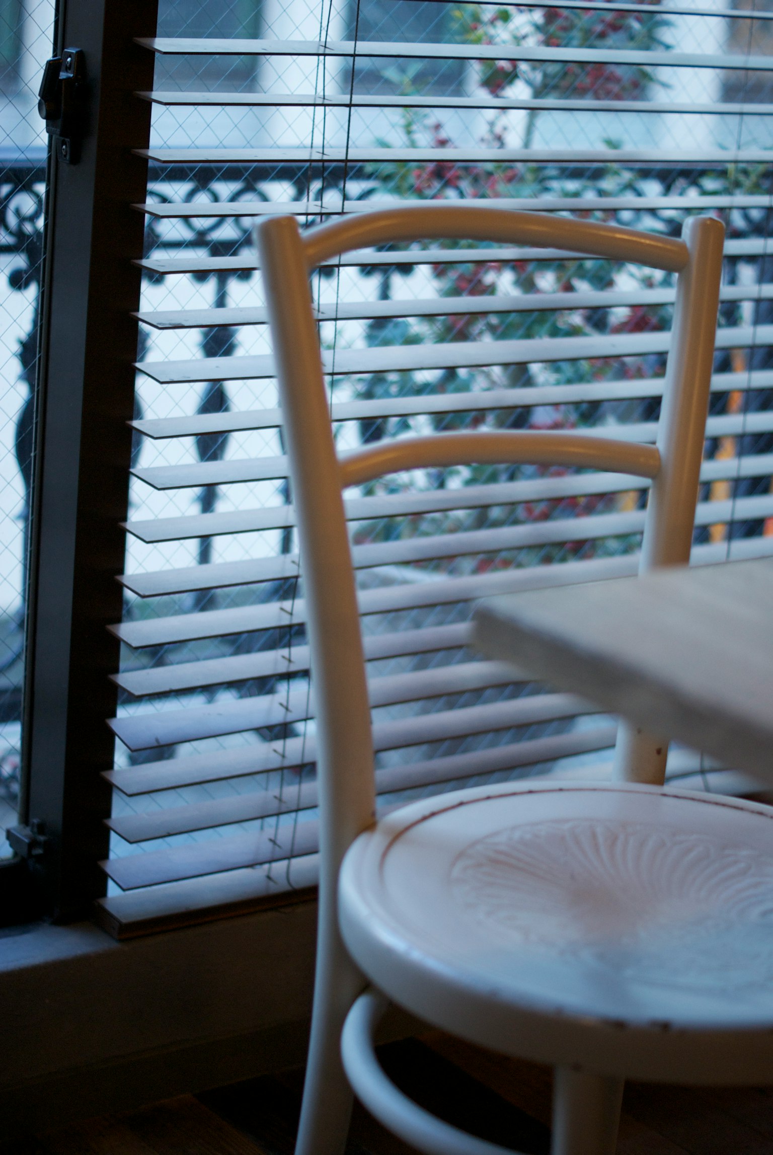 창가 근처에 흰색 의자와 테이블이 있는 카페 내부