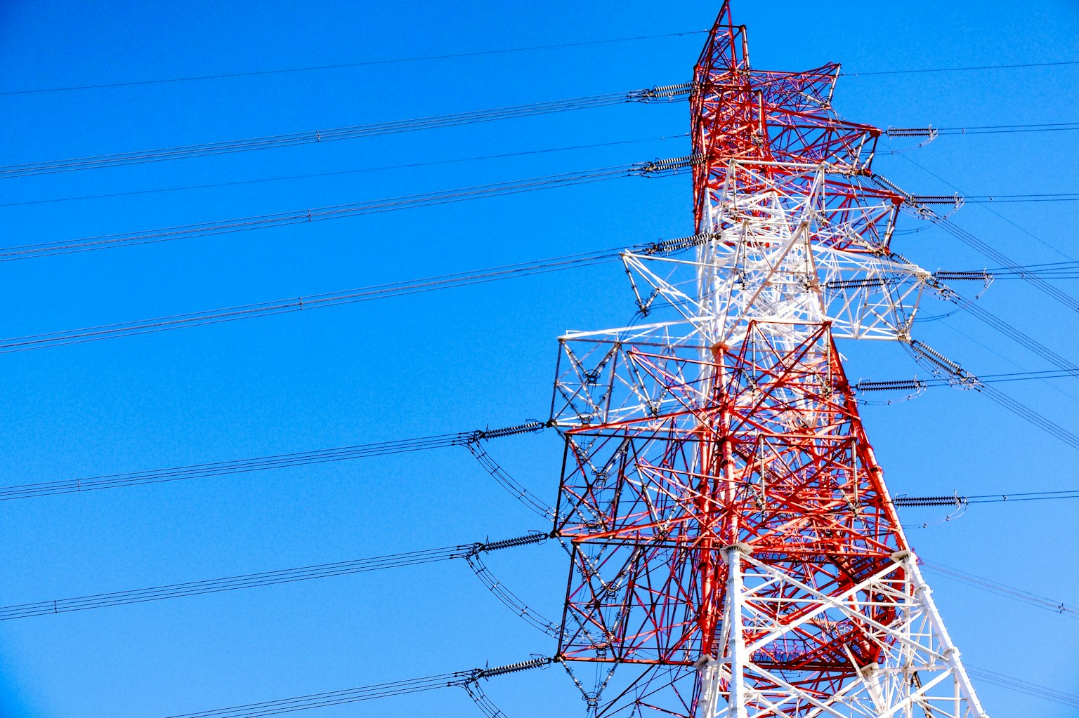 Torre di comunicazione rossa e bianca contro un cielo blu