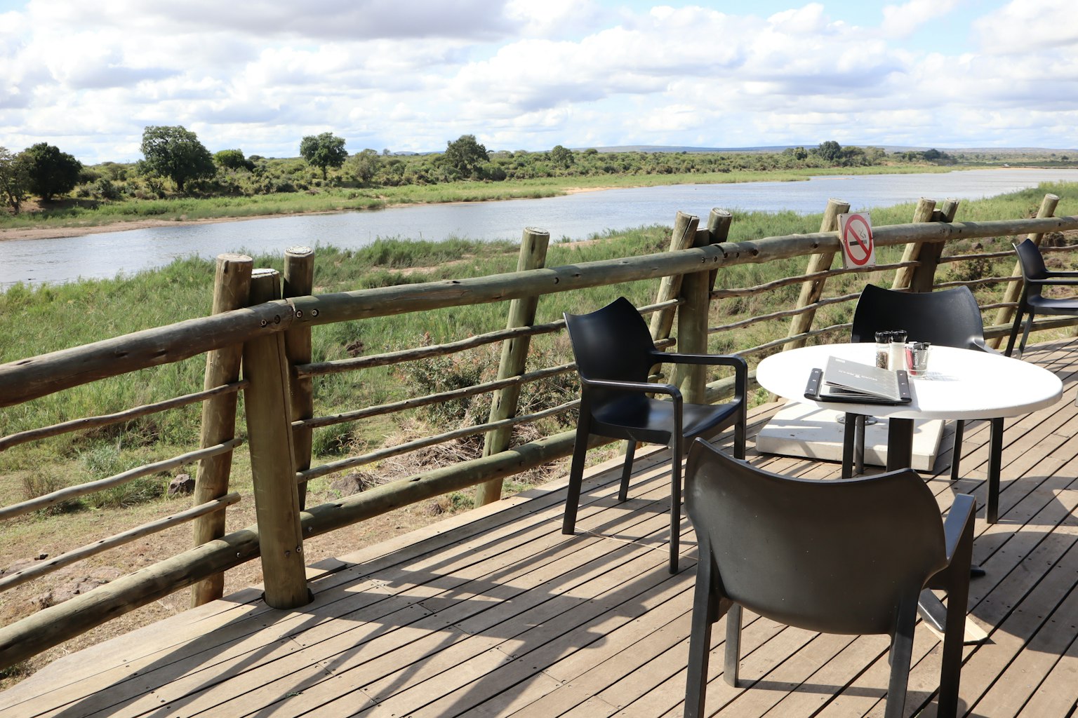 Terrazza esterna con sedie e tavolo che si affaccia su un fiume