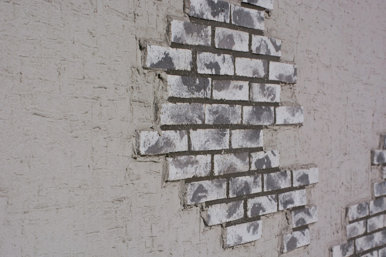Image d'un mur en briques blanches partiellement écaillé
