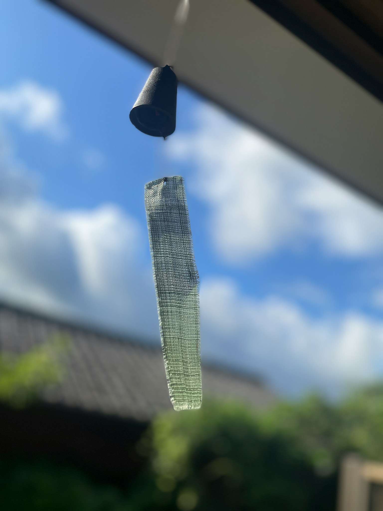 在蓝天下悬挂的透明风铃和黑色盖子