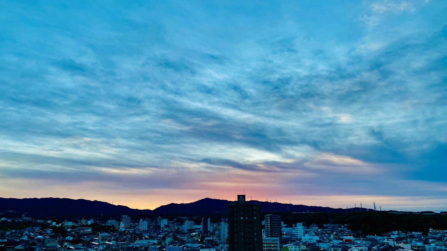 Skyline de la ville au coucher du soleil avec des couleurs vives et des nuages en couches