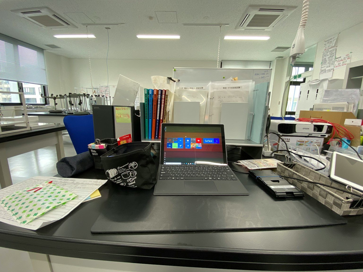 Laptop di atas meja di laboratorium dengan dokumen yang teratur