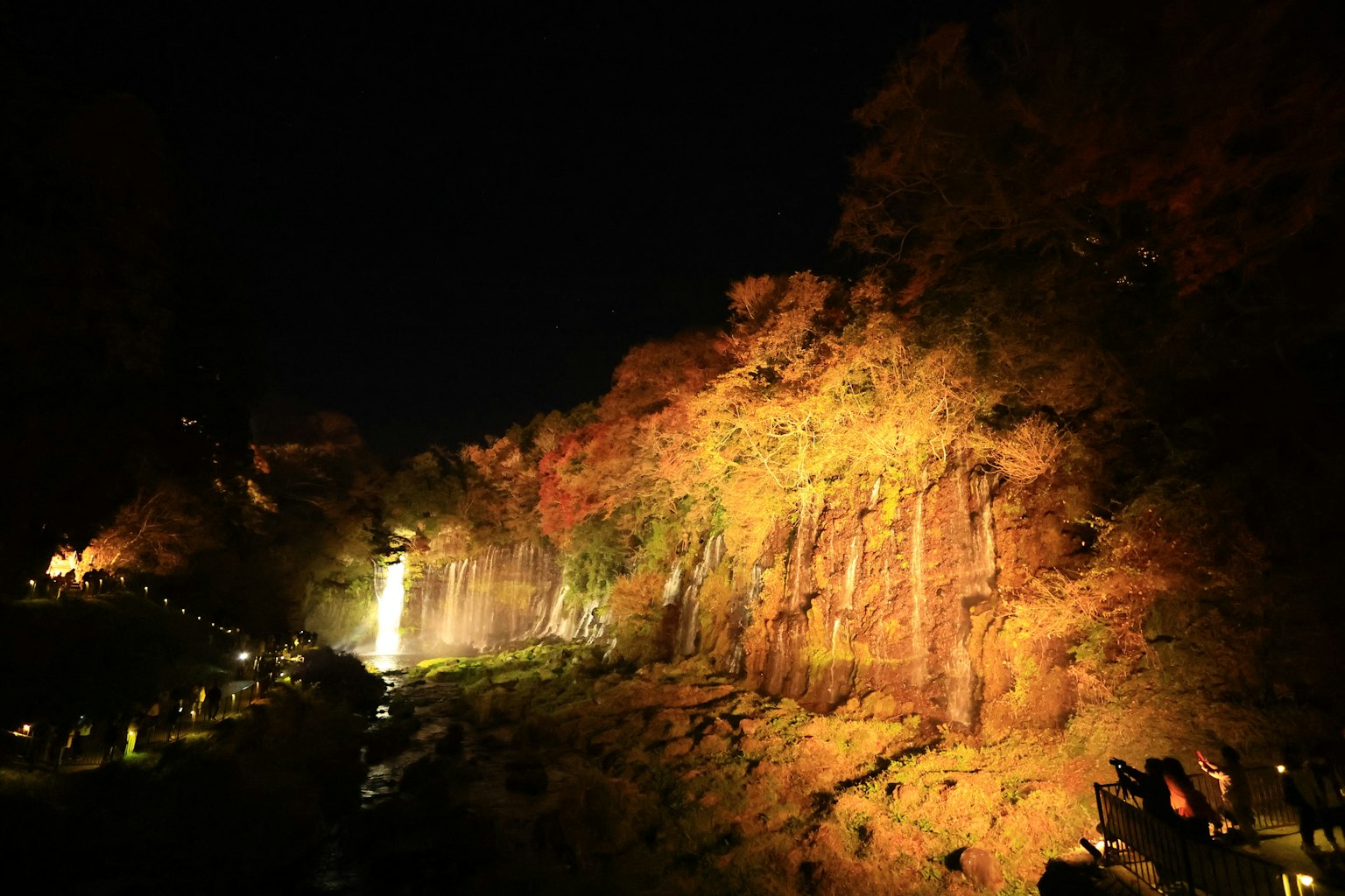ทิวทัศน์ยามค่ำคืนที่สวยงามของน้ำตกและใบไม้ฤดูใบไม้ร่วง
