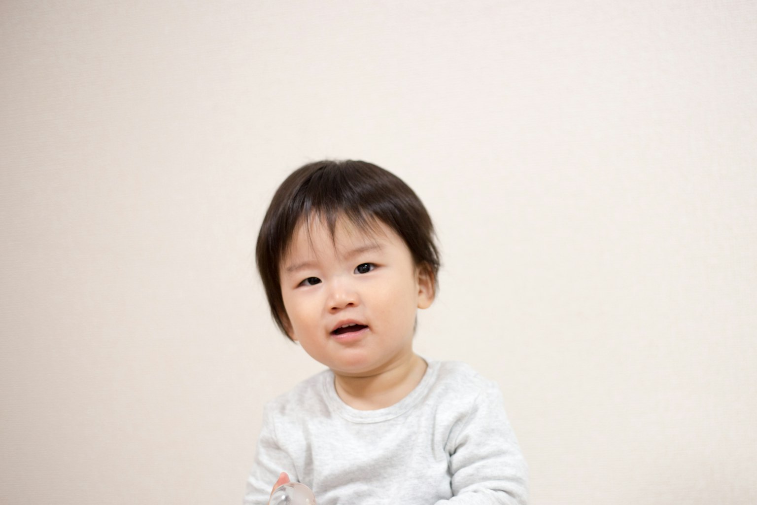 ภาพพอร์ตเทรตของเด็กที่ยิ้มอยู่หน้าพื้นหลังสีขาว