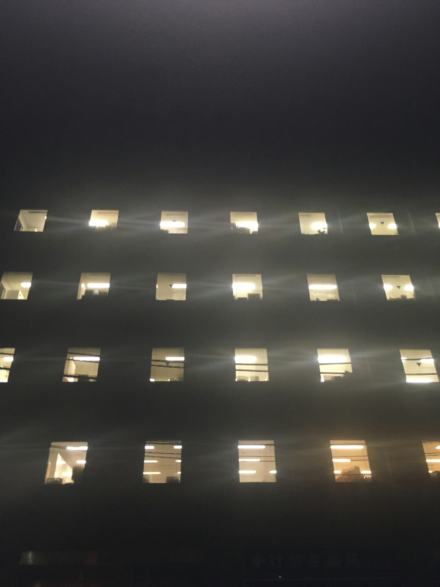Beleuchtete Fenster eines Gebäudes bei Nacht schaffen eine beeindruckende Fassade
