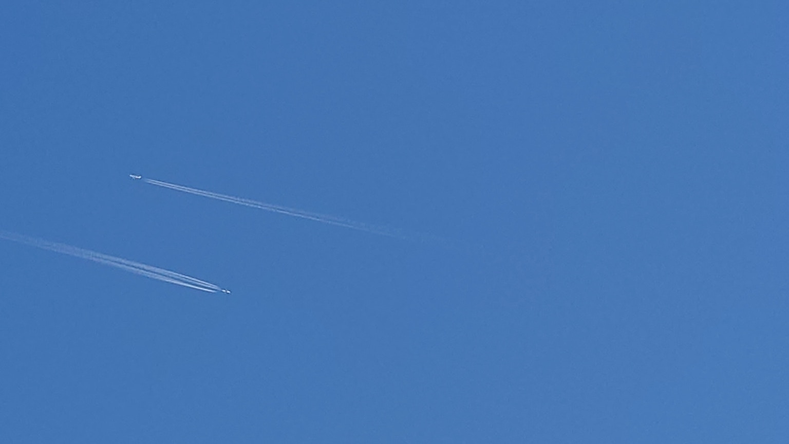 Kondensstreifen in einem klaren blauen Himmel sichtbar