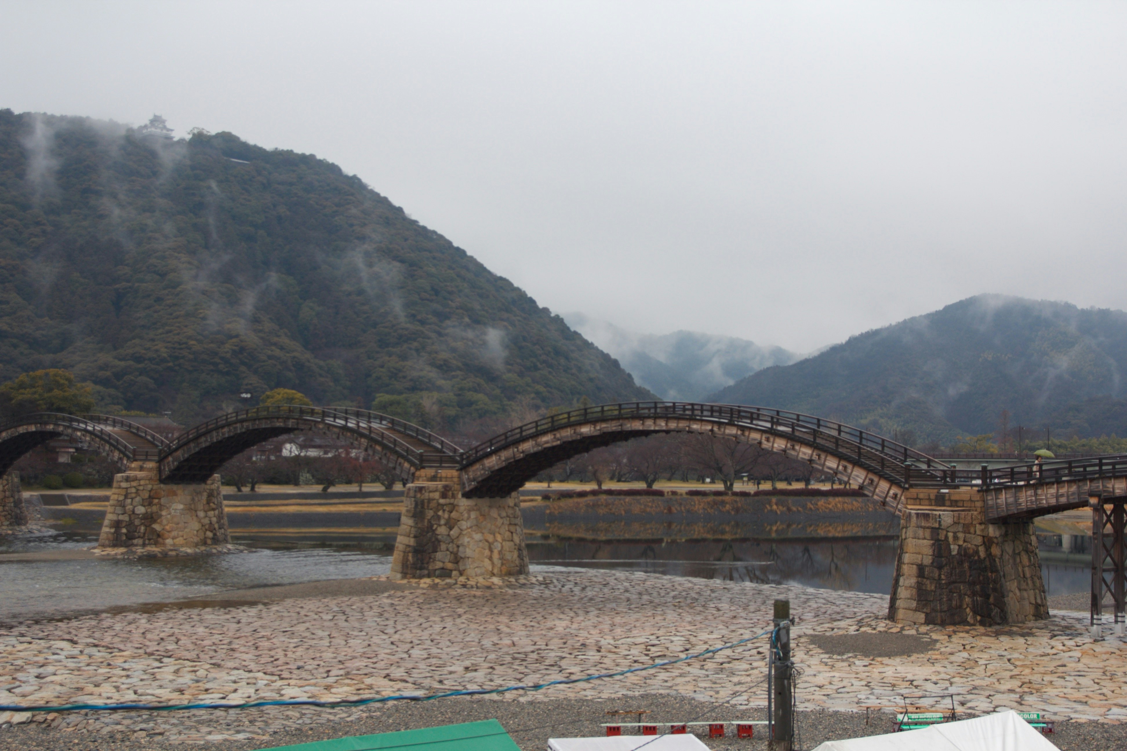川に架かる石造りのアーチ橋と山並みの風景