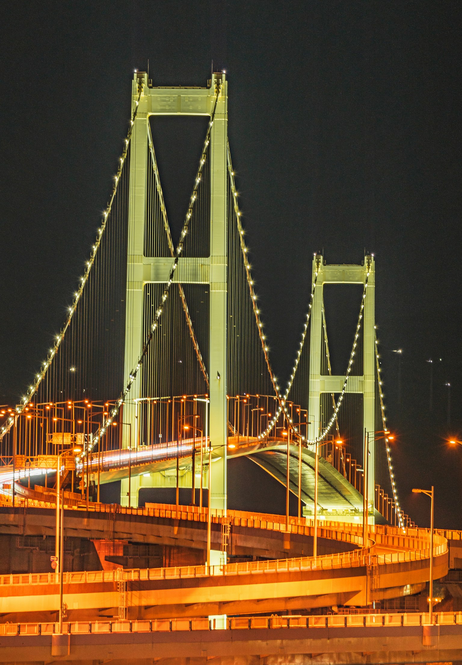 Ponte illuminato di notte con luci di auto in movimento