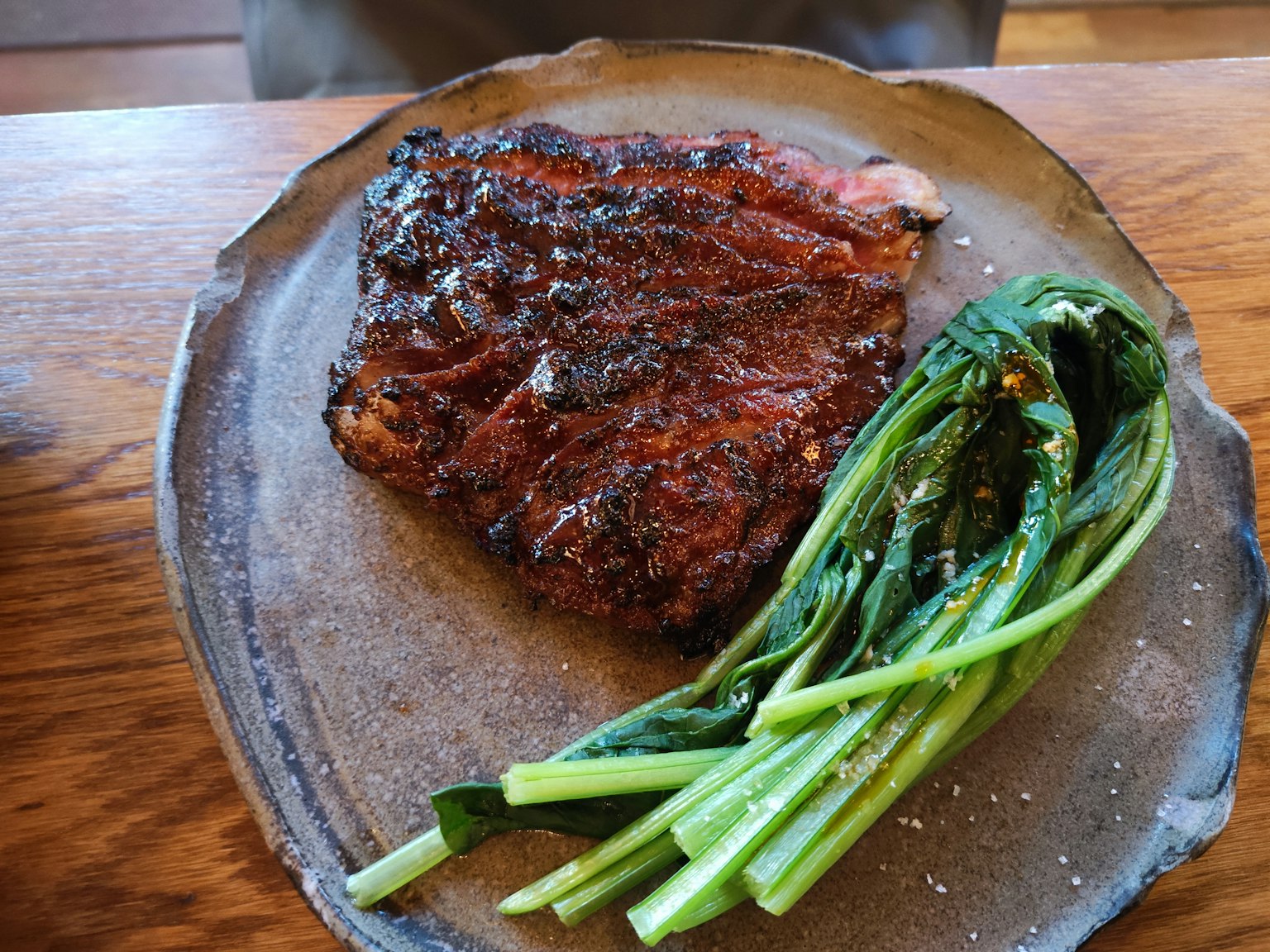 Gegrilltes Steak mit Frühlingszwiebeln auf einem rustikalen Teller