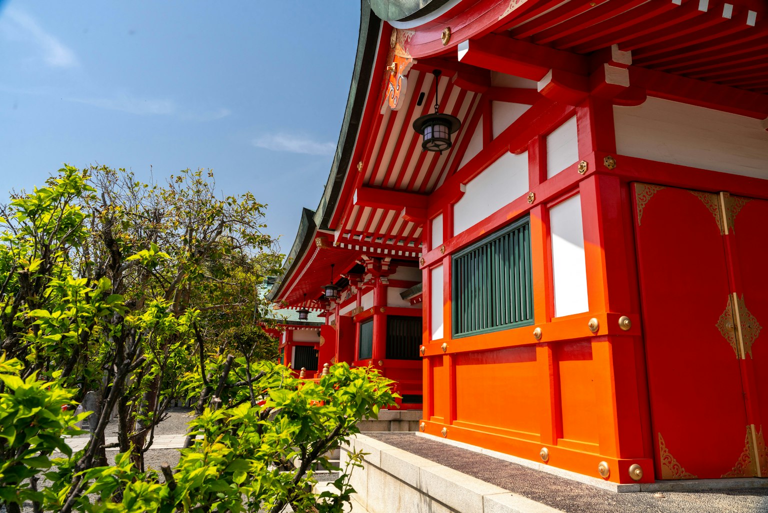 Vibrant red building with intricate architecture against a clear blue sky