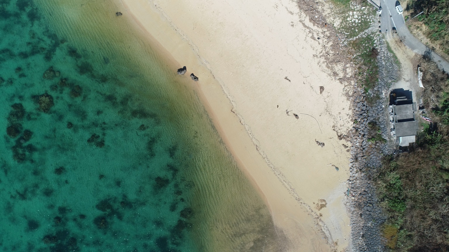 Vista aérea de una playa con aguas turquesas y arena dorada