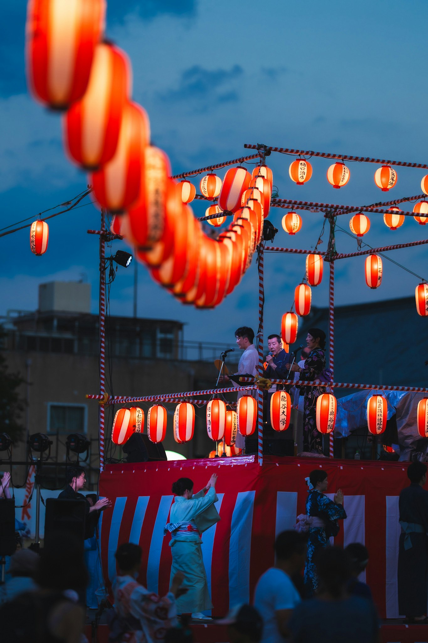 提灯が連なる夏祭りの盆踊り会場の夜景