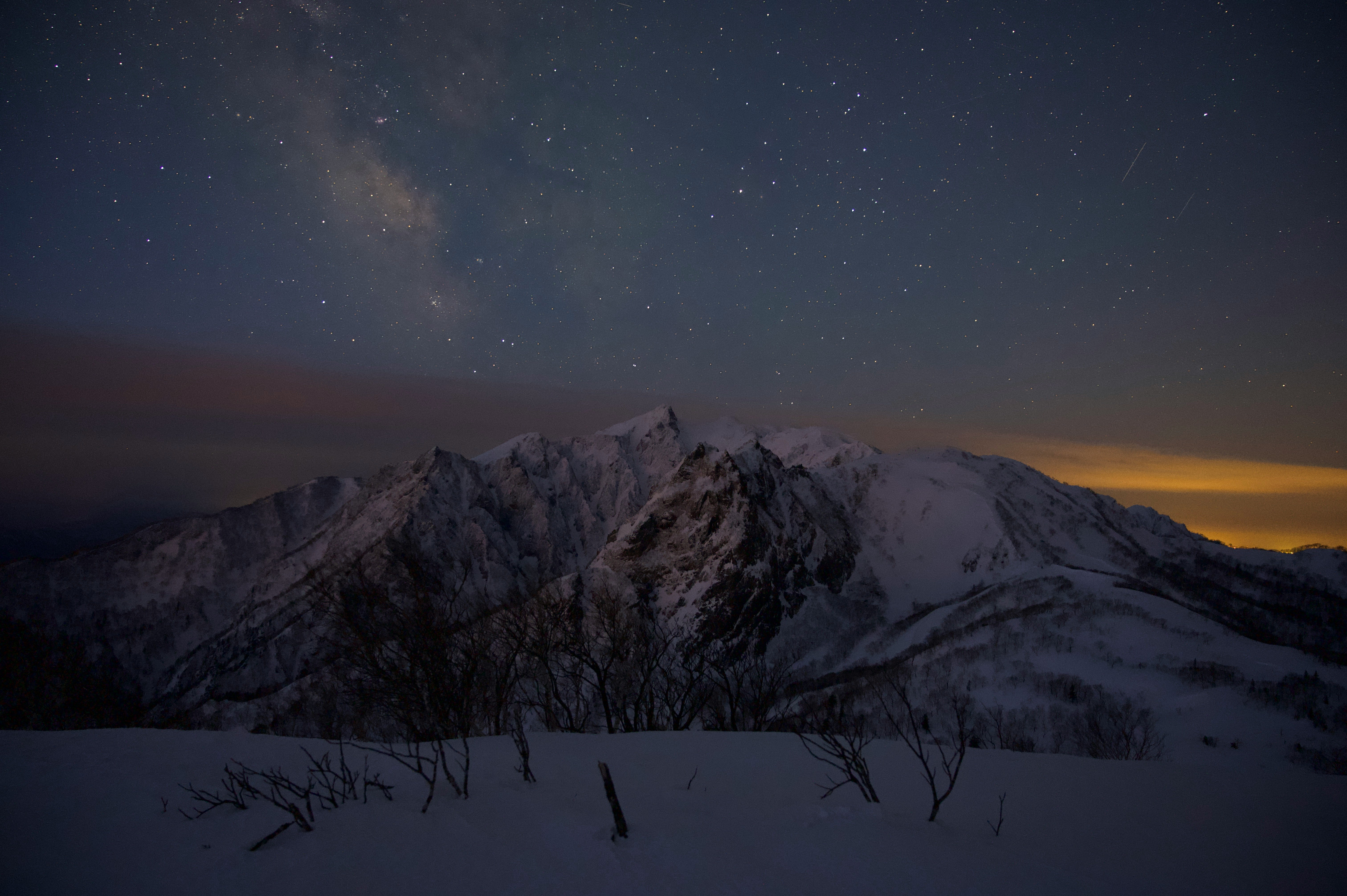 雪山と星空が広がる夜の風景