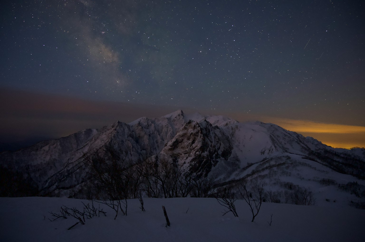 Montañas cubiertas de nieve bajo un cielo estrellado
