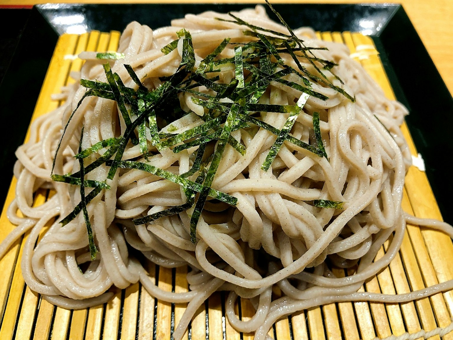 美麗的蕎麥麵盛在竹席上，上面點綴著海苔