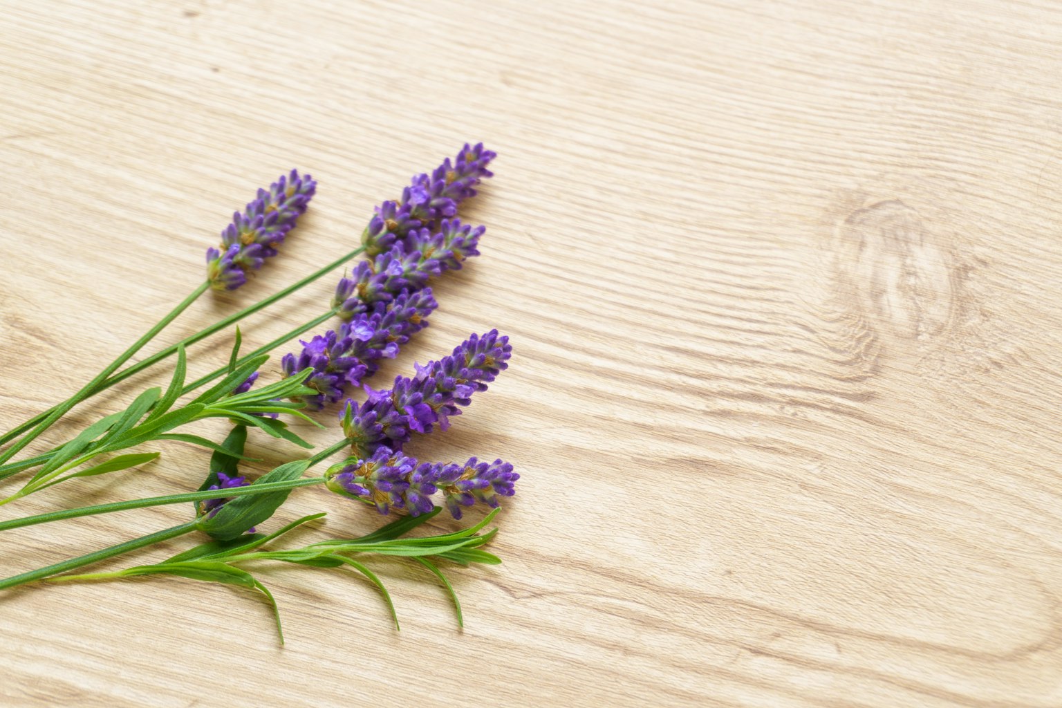 Un mazzo di fiori di lavanda viola posato su un tavolo di legno