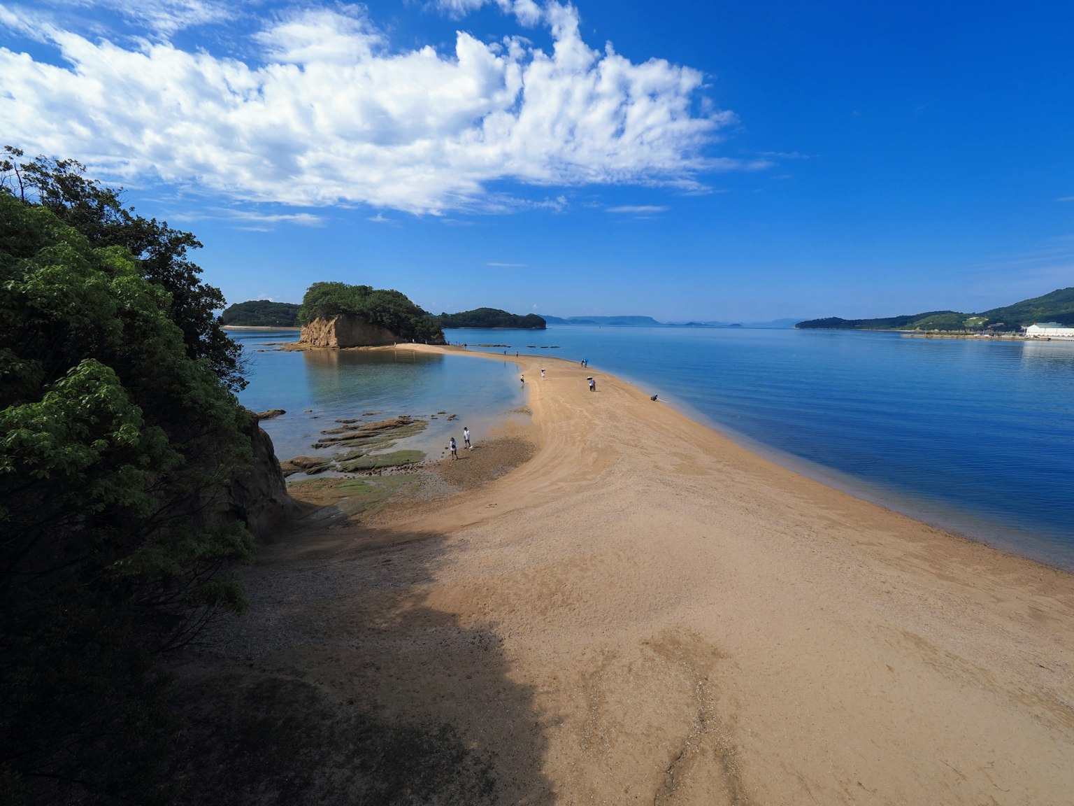 Beach with golden sand and calm blue water under a clear sky