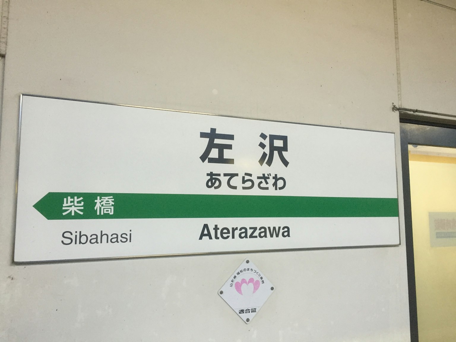 左泽站的标识，带有绿色箭头和文字