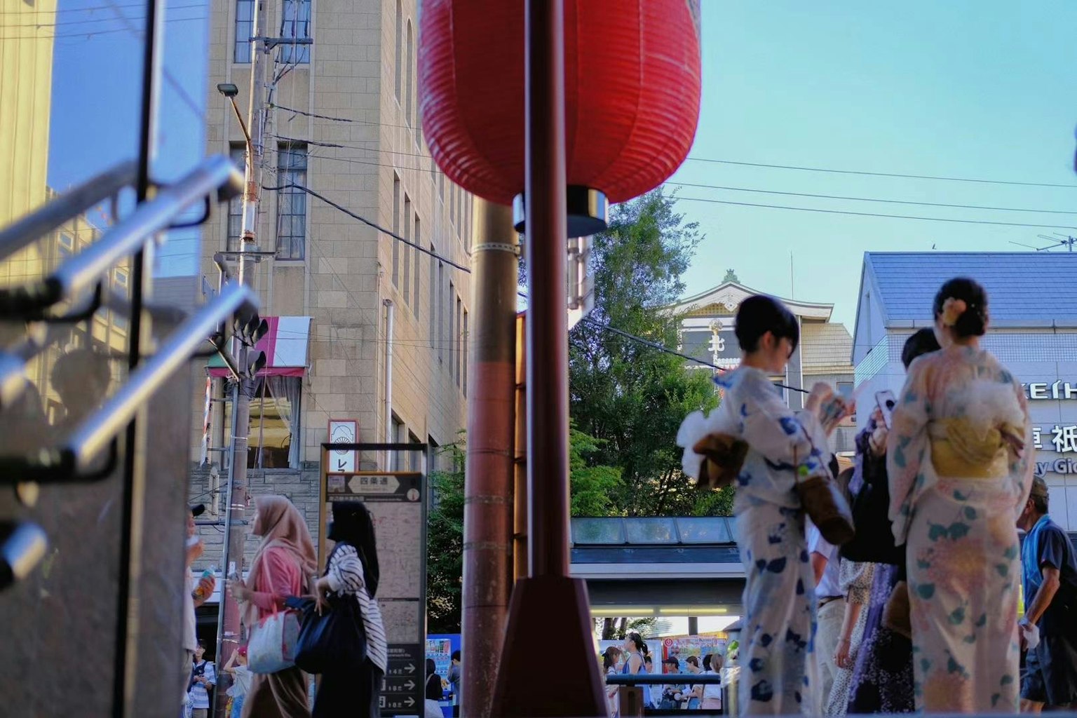 People in yukata gather in a Japanese street at dusk