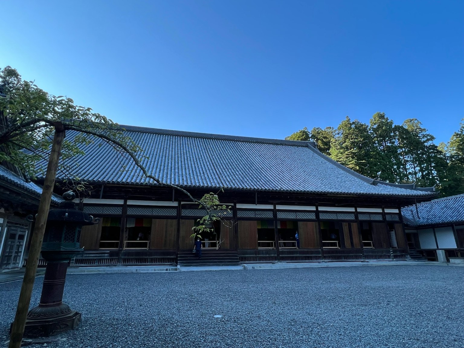 Bangunan tradisional Jepang di taman tenang dengan langit biru yang cerah