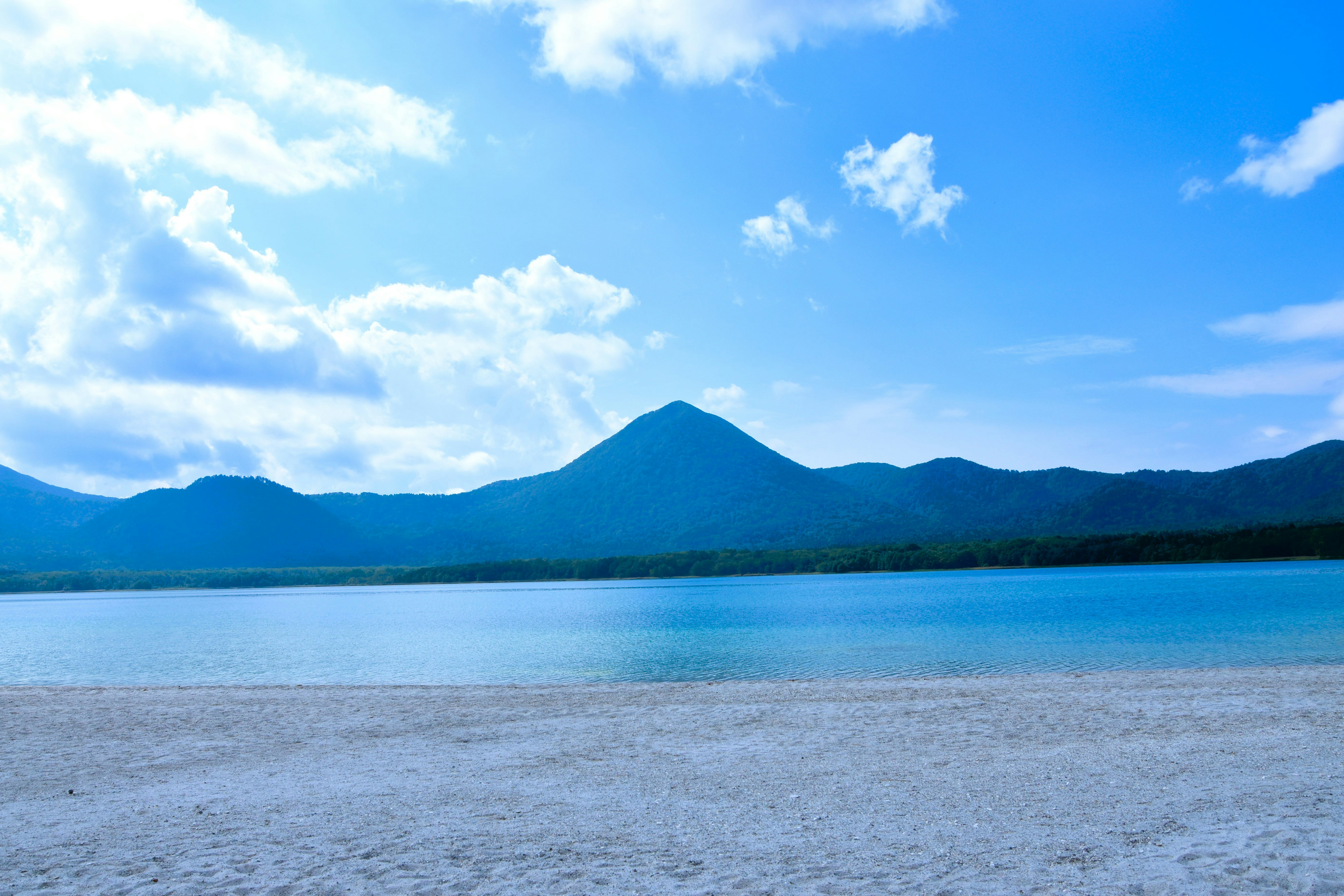 青空の下の湖畔と遠くの山