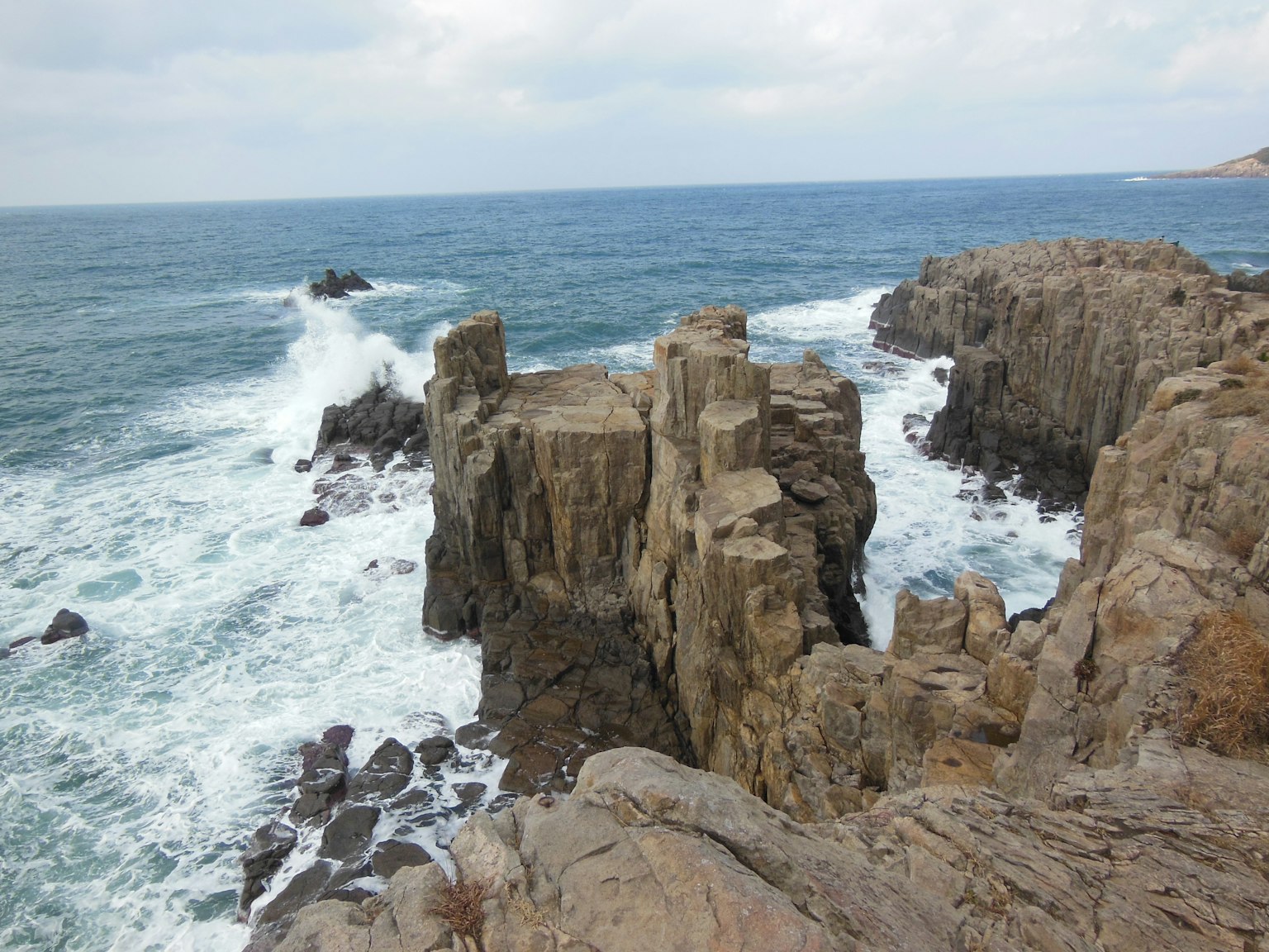 岩石海岸懸崖與拍打的海浪和海洋景觀