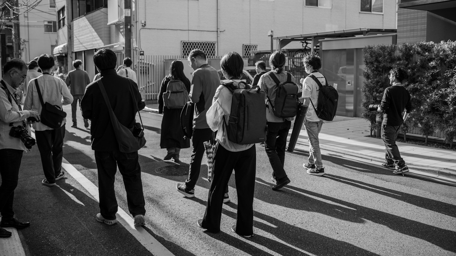 Eine Gruppe von Menschen, die auf einer Stadtstraße in Schwarzweiß gehen