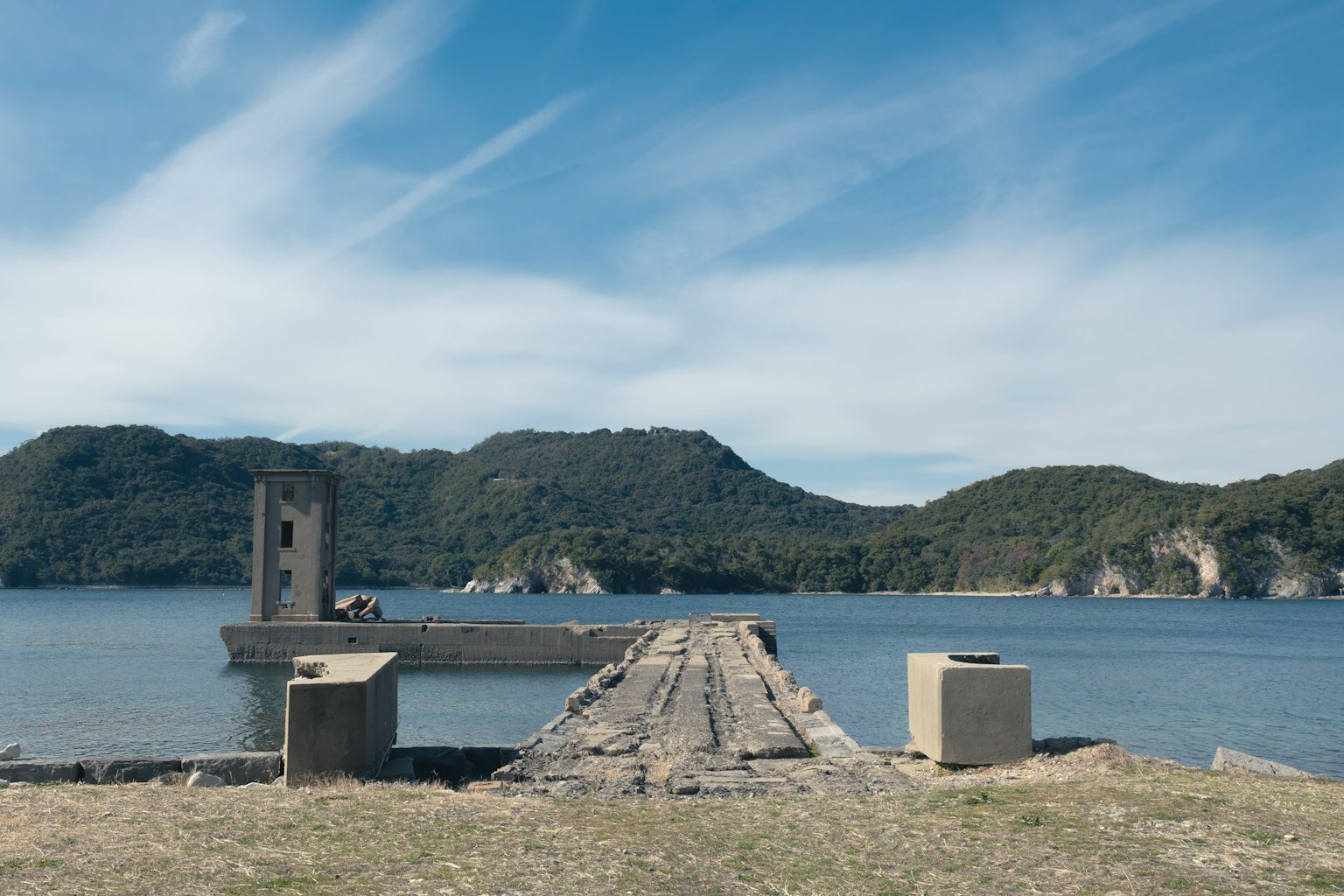 静かな湖に向かう古い桟橋と周囲の山々