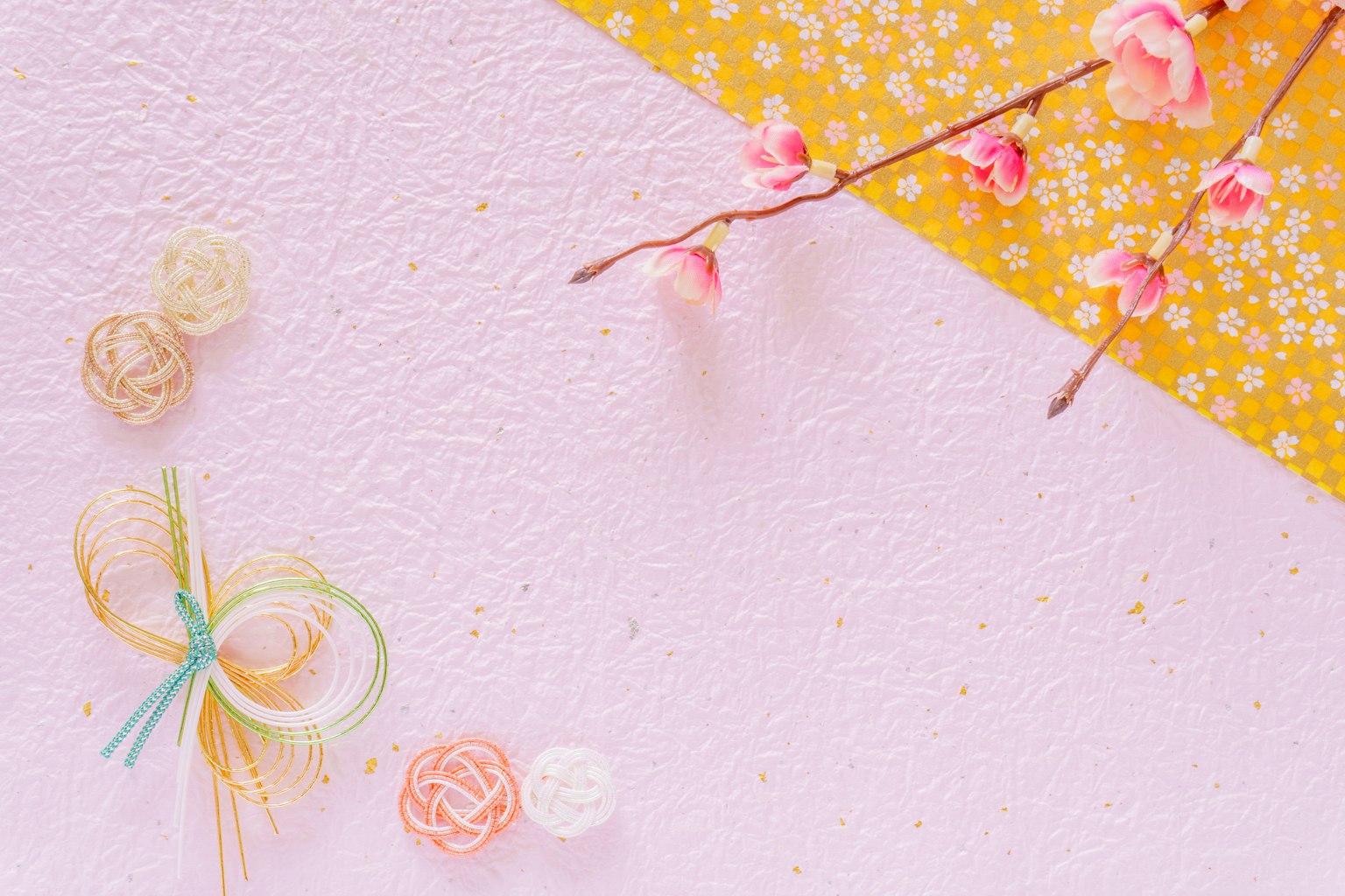 Uno sfondo rosa con un angolo a motivi gialli che presenta rami di ciliegio e fiori decorativi