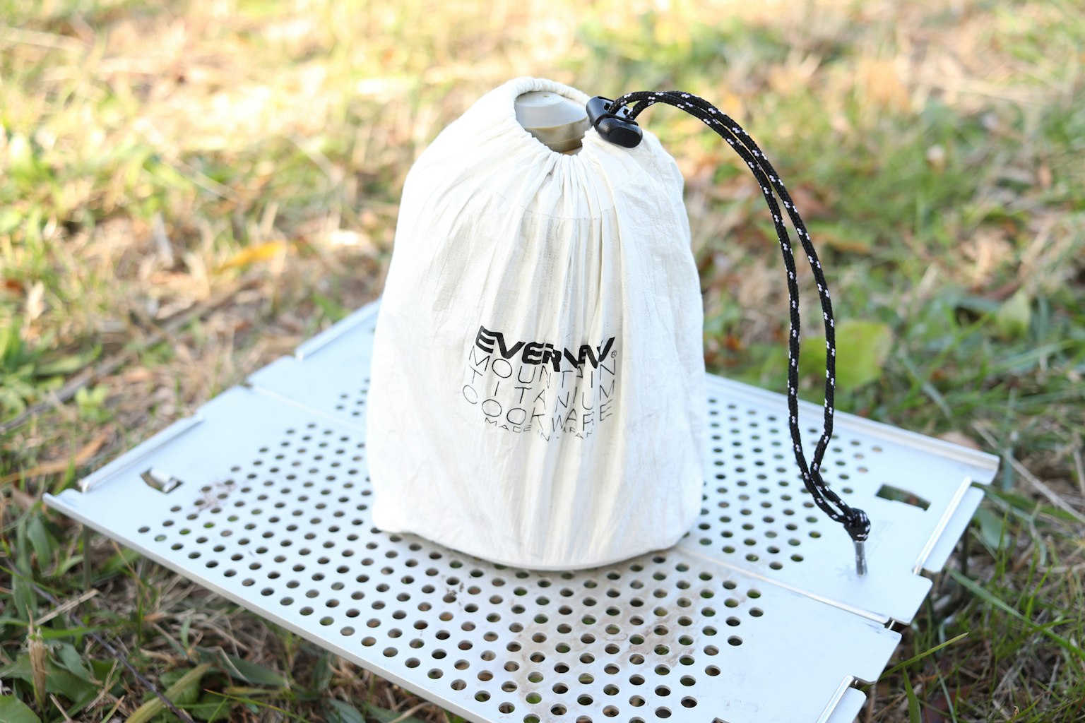 A white drawstring bag placed on green grass