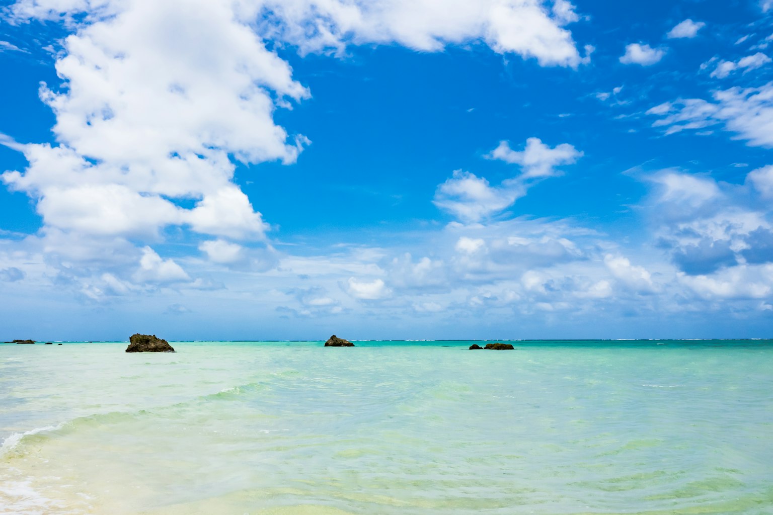 海灘場景，藍天和白雲 平靜的海洋，清澈的水面和分散的岩石