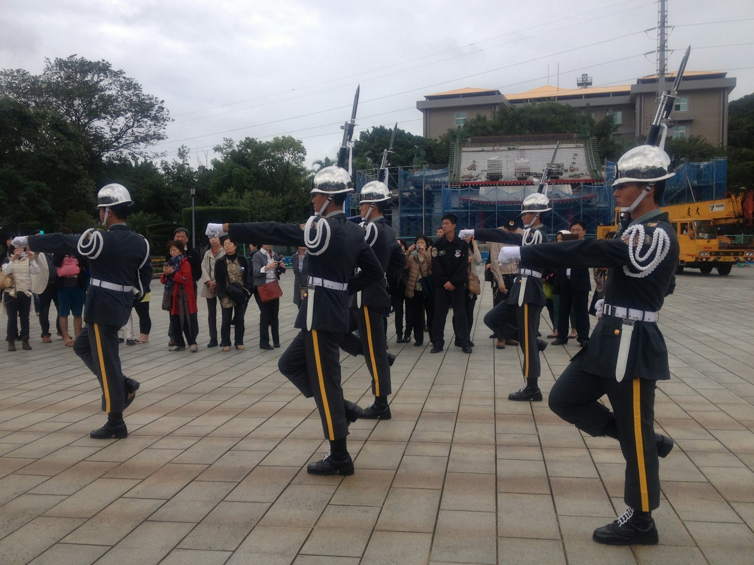 Soldats en uniforme marchant avec des spectateurs en arrière-plan