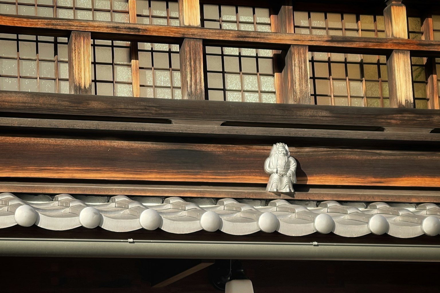 古老日本建築屋頂上的白色裝飾雕像