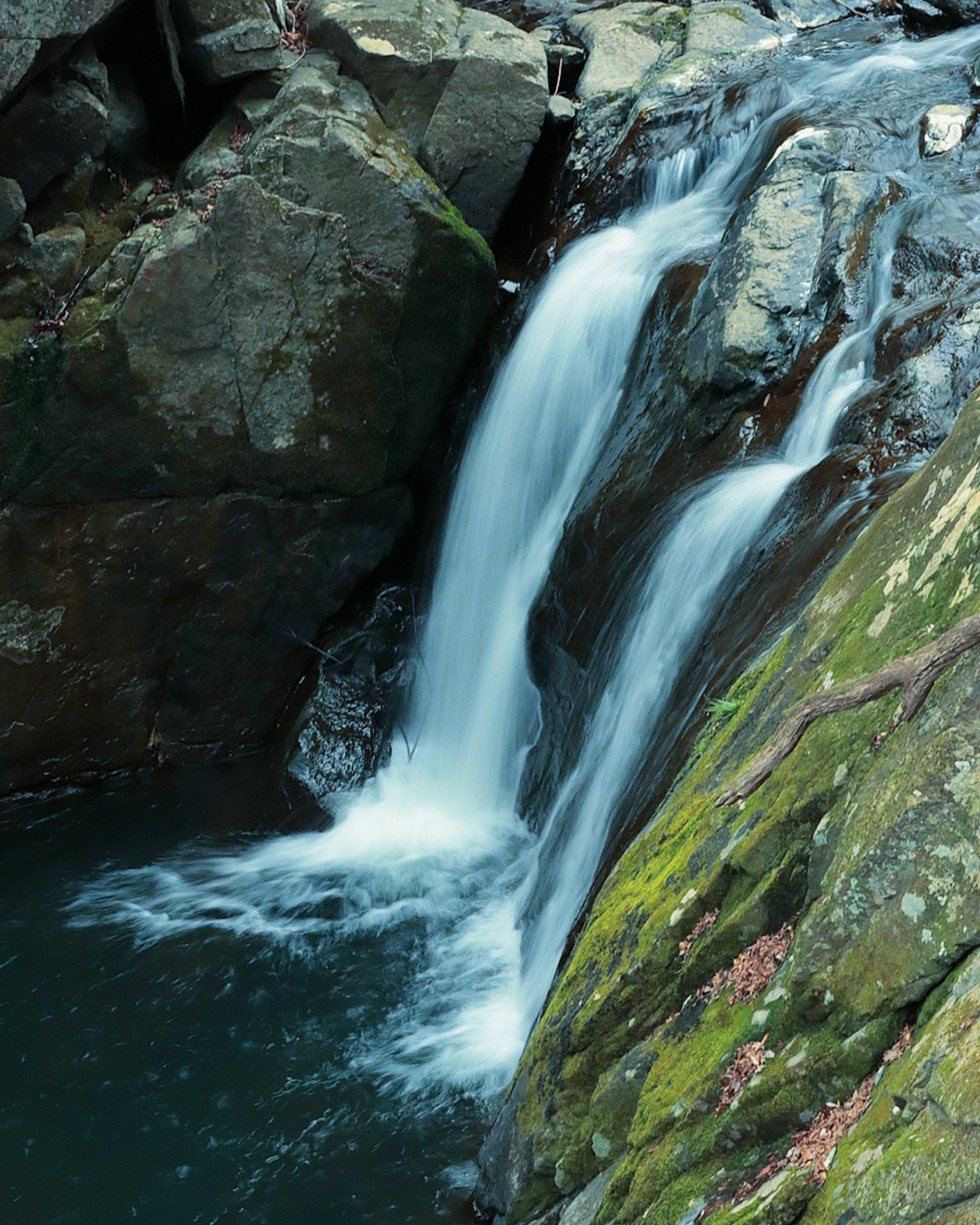 Beautiful waterfall cascading between moss-covered rocks
